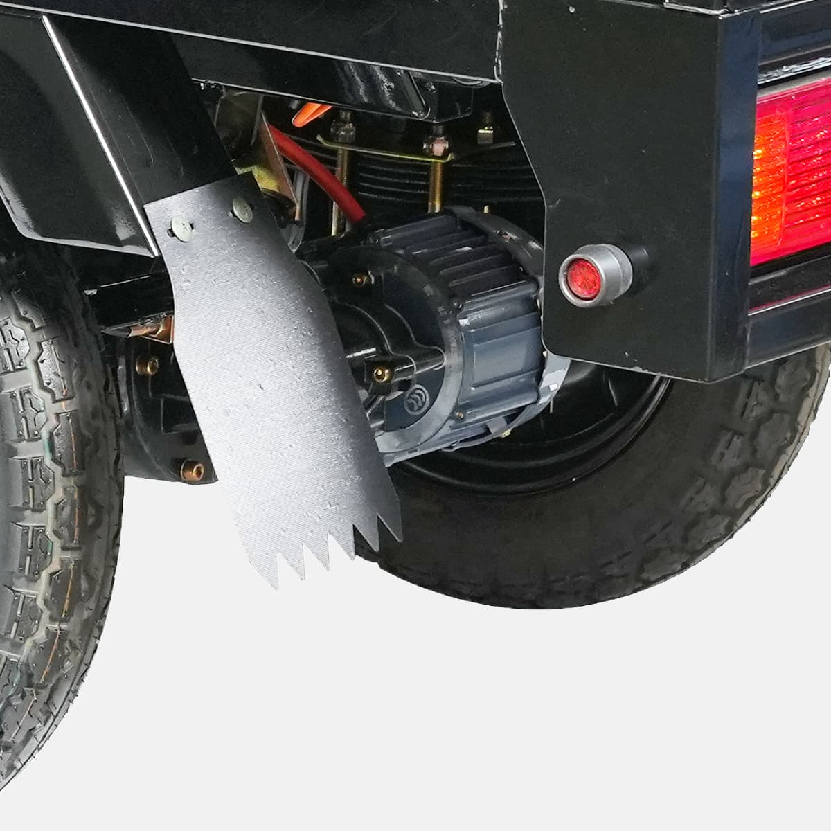 Close-up of a vehicle's rear wheel and suspension system on a gray background