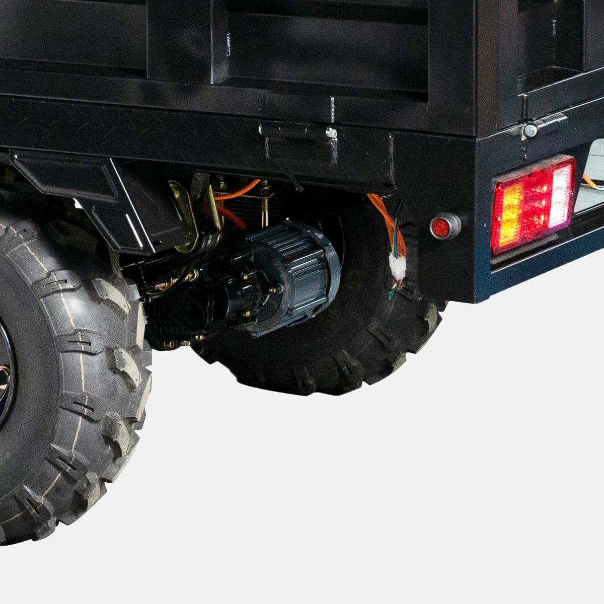 Close-up of a vehicle's undercarriage with a focus on the wheel and rear lights.