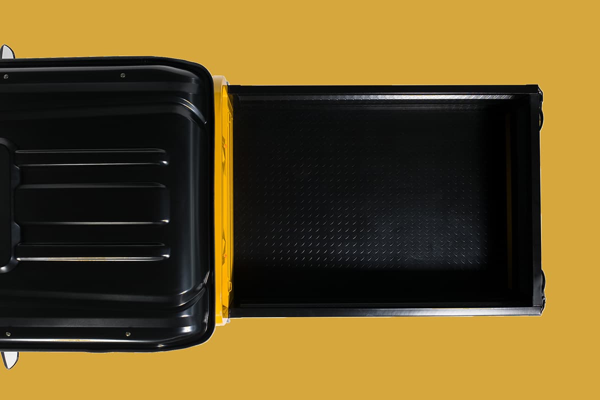Black metal tray with yellow interior on a yellow background