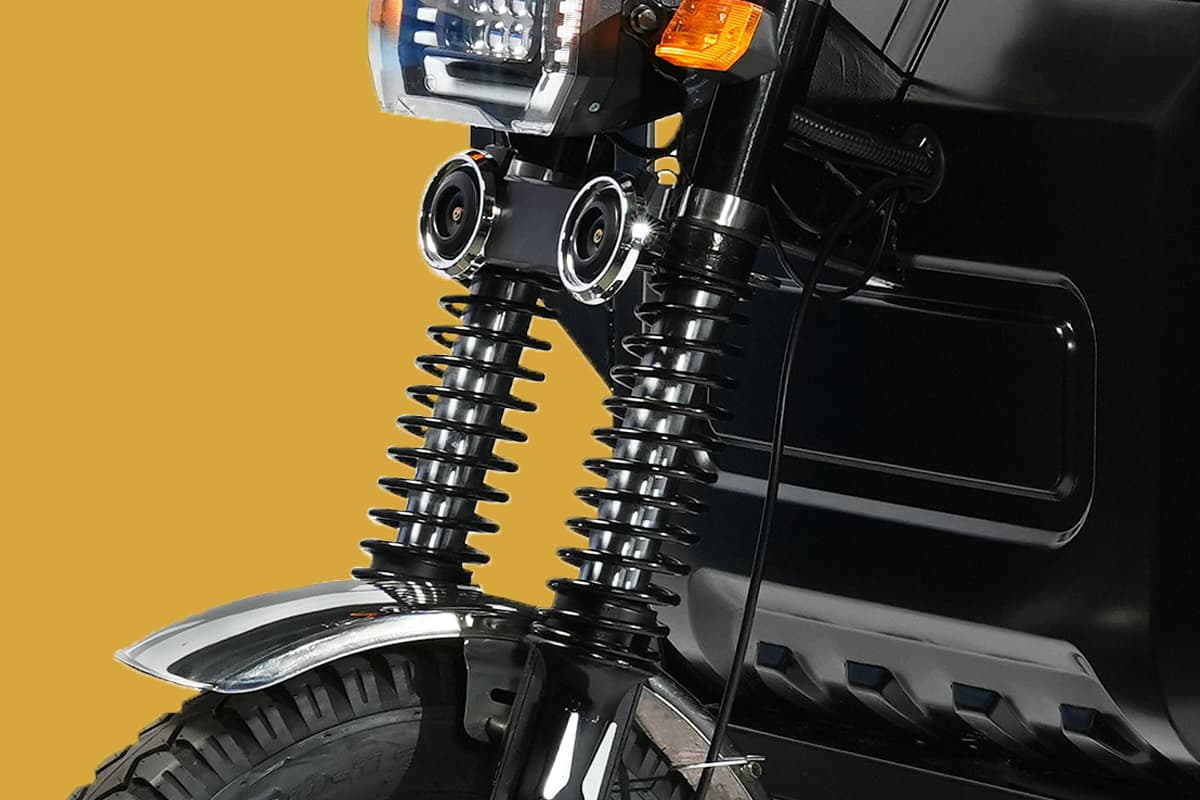 Close-up of a motorcycle's suspension system on a yellow background