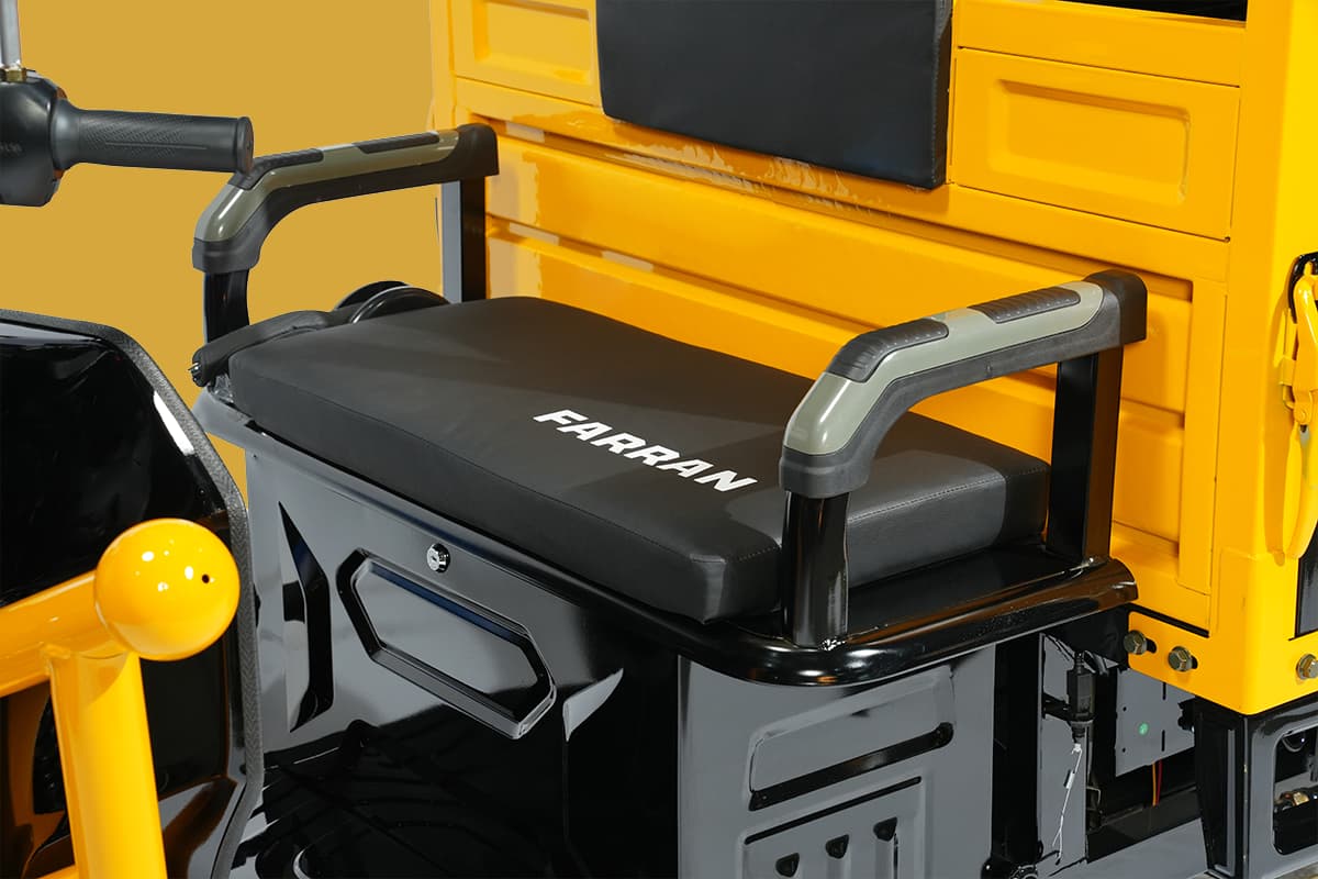 Black seat with 'Farran' branding on a yellow construction vehicle.