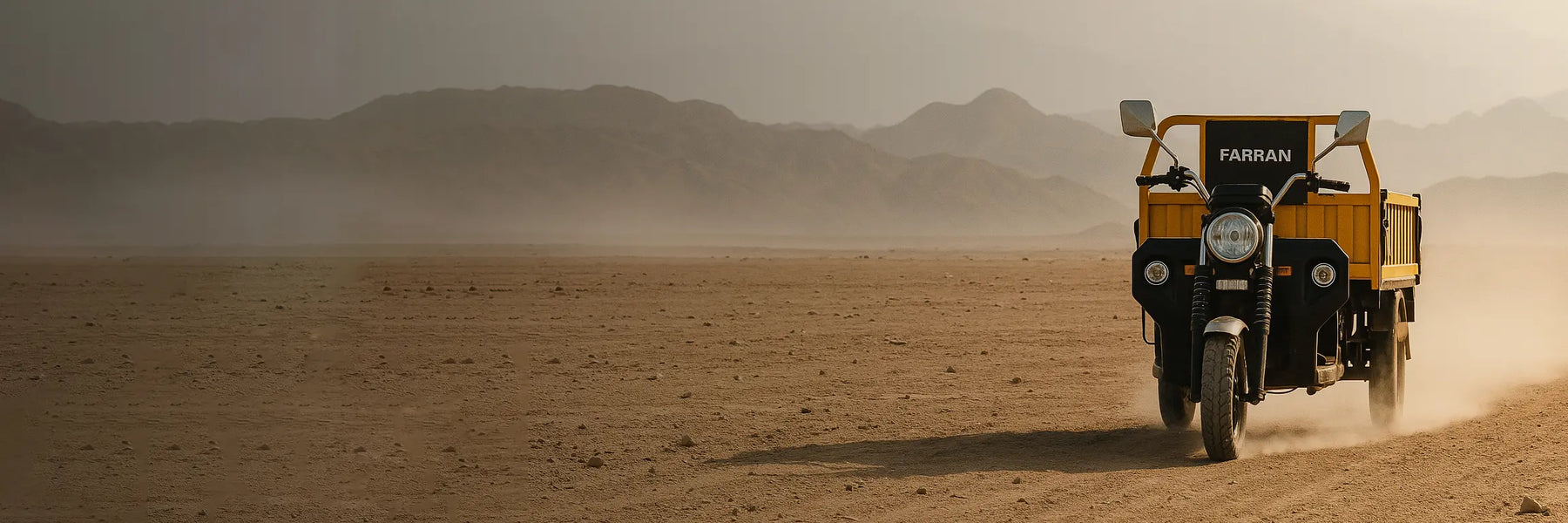 Yellow off-road vehicle on a desert road with mountains in the background
